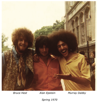 3 guys with long hair in front of the castle